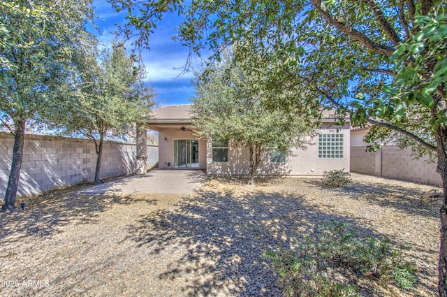 rear view of property with ceiling fan, a patio area, a fenced backyard, and stucco siding