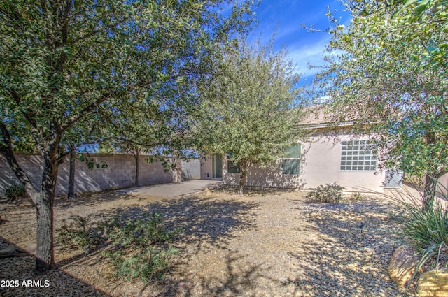 view of front of house with a patio area and fence