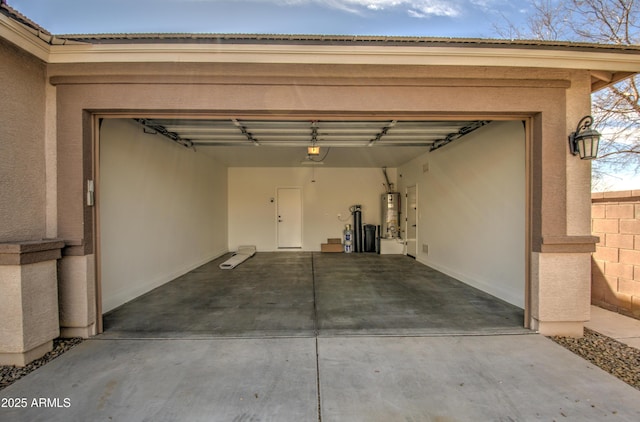 garage featuring a garage door opener, water heater, and driveway