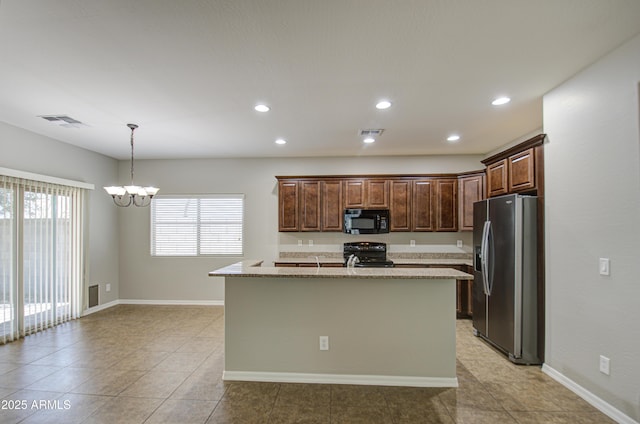 kitchen with visible vents, an island with sink, decorative light fixtures, an inviting chandelier, and black appliances