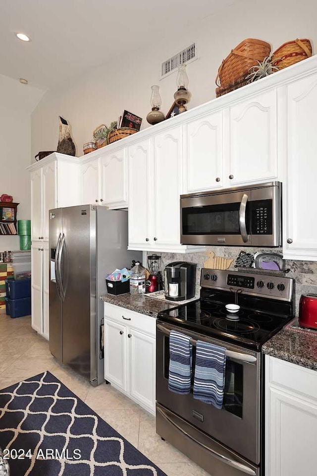 kitchen featuring dark stone counters, appliances with stainless steel finishes, visible vents, and white cabinetry