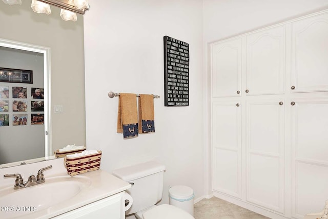 bathroom featuring toilet, a closet, and vanity