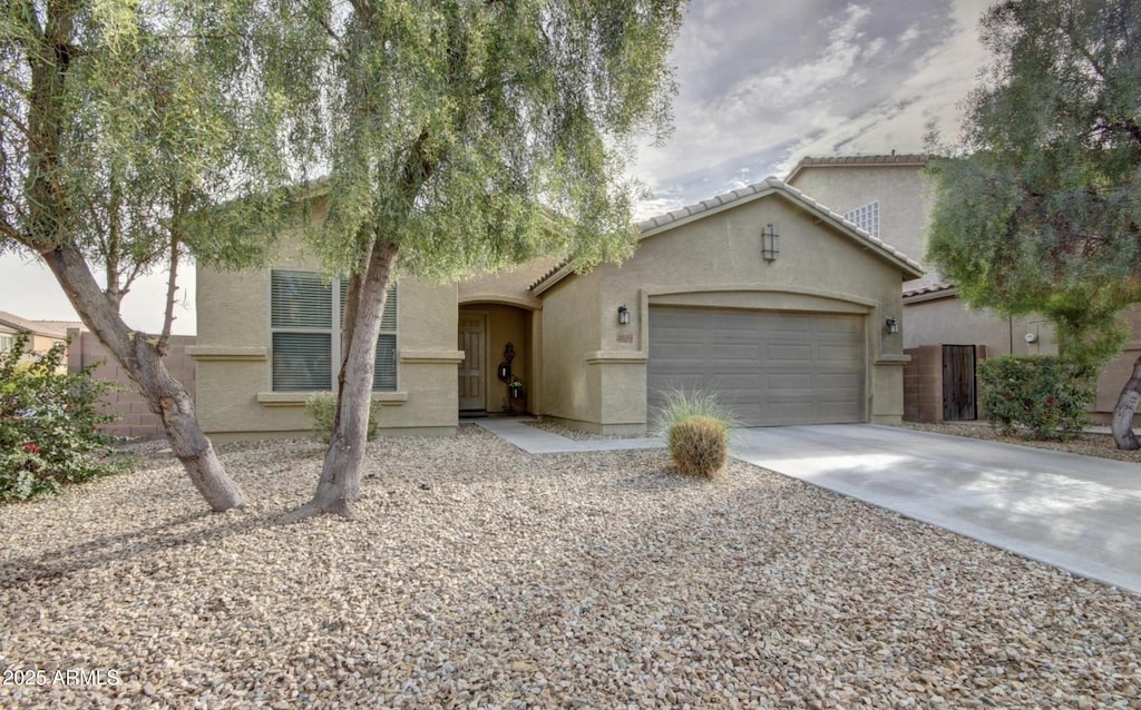3821 S 100th Gln, Tolleson, AZ 85353 - view of front of home featuring stucco siding, a garage, and driveway