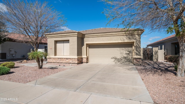 view of front of house featuring stone siding, stucco siding, an attached garage, and driveway