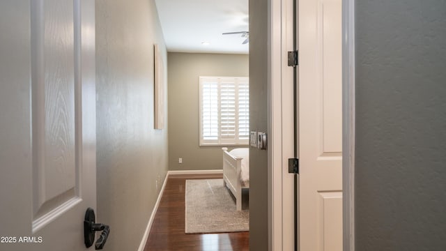 bathroom with a textured wall, baseboards, and wood finished floors