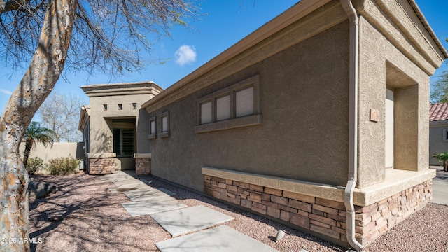 view of home's exterior with stone siding and stucco siding