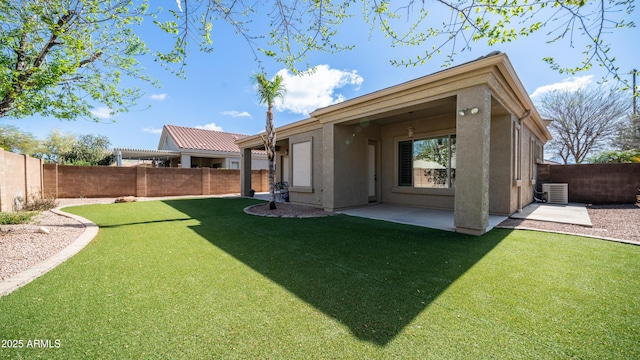 back of property featuring stucco siding, a lawn, and a fenced backyard