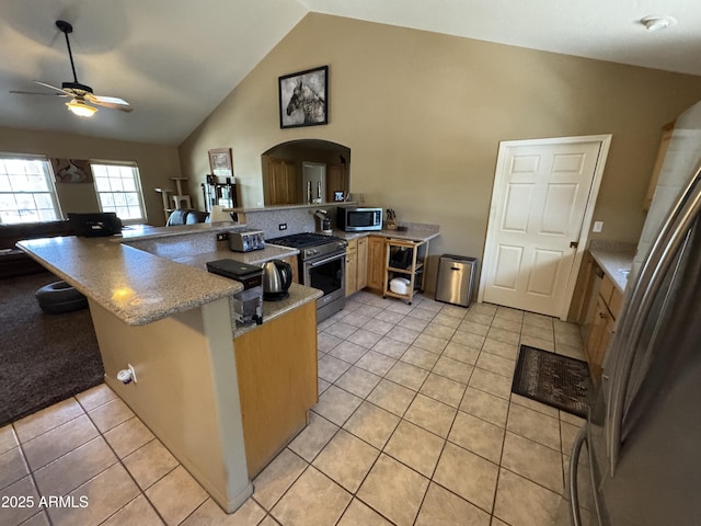 2404 W Palmer Dr, Payson, AZ 85541 - kitchen featuring appliances with stainless steel finishes, a peninsula, a ceiling fan, arched walkways, and light tile patterned flooring