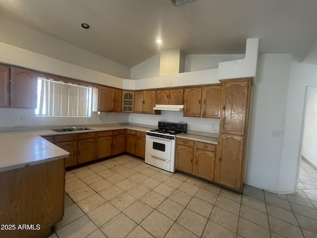 403 E 6th St, Douglas, AZ 85607 - kitchen with white gas range oven, vaulted ceiling, under cabinet range hood, light countertops, and brown cabinets