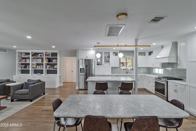 1839 E Palo Verde Dr, Phoenix, AZ 85016 - kitchen featuring stainless steel appliances, premium range hood, a sink, a kitchen island, and wood finished floors