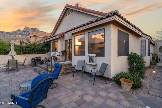 1705 E Deer Shadow Ln, Tucson, AZ 85737 - patio terrace at dusk featuring a patio, grilling area, a mountain view, and outdoor dining area