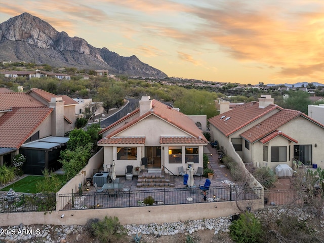 1705 E Deer Shadow Ln, Tucson, AZ 85737 - view of front of property featuring a mountain view, a fenced backyard, a chimney, a patio area, and a tiled roof