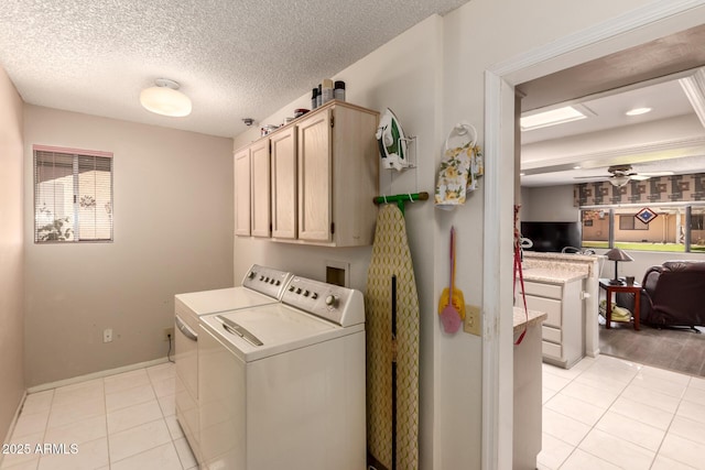 washroom with light tile patterned floors, washer and clothes dryer, cabinet space, and a ceiling fan