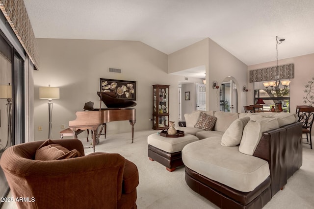 living room featuring a notable chandelier, visible vents, vaulted ceiling, arched walkways, and light colored carpet
