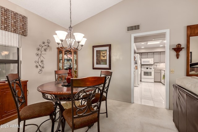 dining area featuring visible vents, baseboards, an inviting chandelier, vaulted ceiling, and light carpet