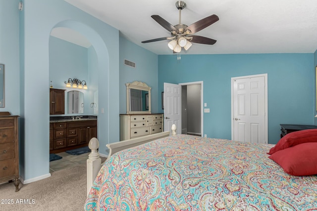 bedroom with connected bathroom, lofted ceiling, sink, light colored carpet, and ceiling fan