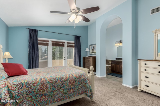 bedroom with ceiling fan, ensuite bathroom, vaulted ceiling, and light carpet