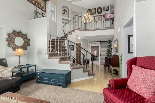 interior space with a towering ceiling, a chandelier, and light hardwood / wood-style floors