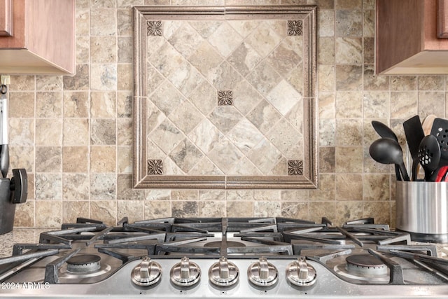 details featuring decorative backsplash and stainless steel gas cooktop