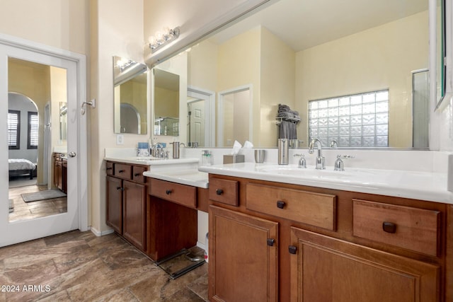 bathroom featuring vanity, a shower with shower door, and a healthy amount of sunlight