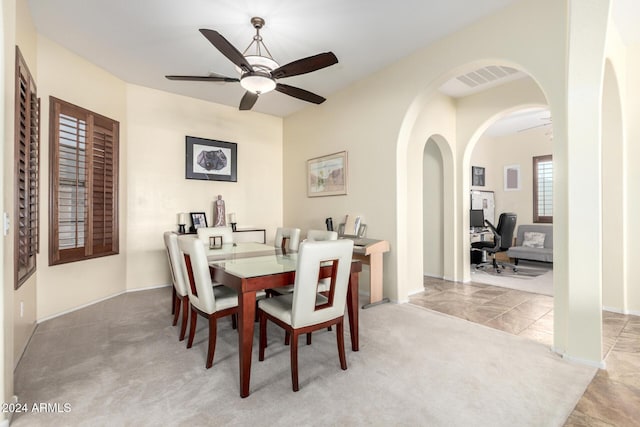 carpeted dining space with ceiling fan