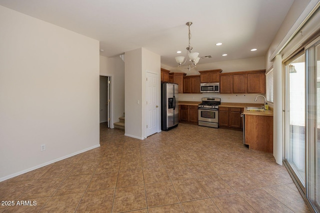 kitchen with plenty of natural light, a sink, appliances with stainless steel finishes, and a chandelier