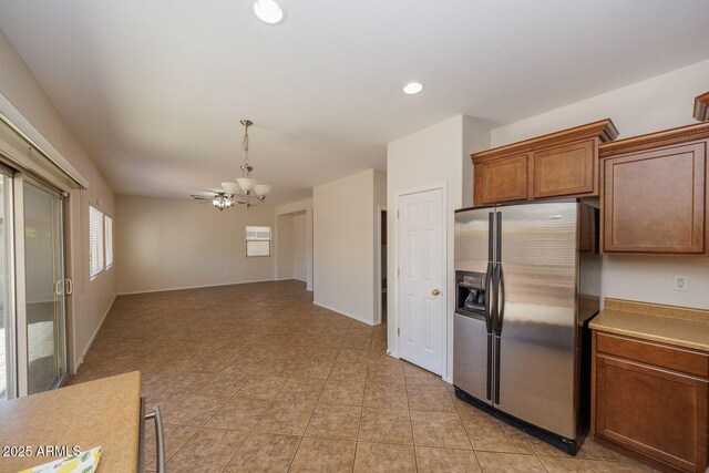 kitchen with hanging light fixtures, light countertops, stainless steel fridge with ice dispenser, a chandelier, and recessed lighting