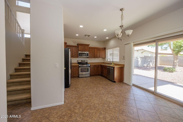 kitchen with appliances with stainless steel finishes, light countertops, a chandelier, recessed lighting, and decorative light fixtures