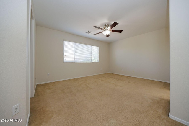 carpeted empty room with visible vents, a ceiling fan, and baseboards
