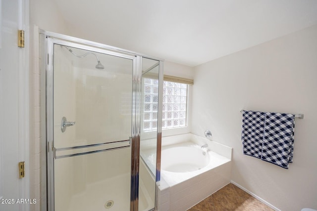 bathroom featuring tile patterned floors, a garden tub, and a stall shower