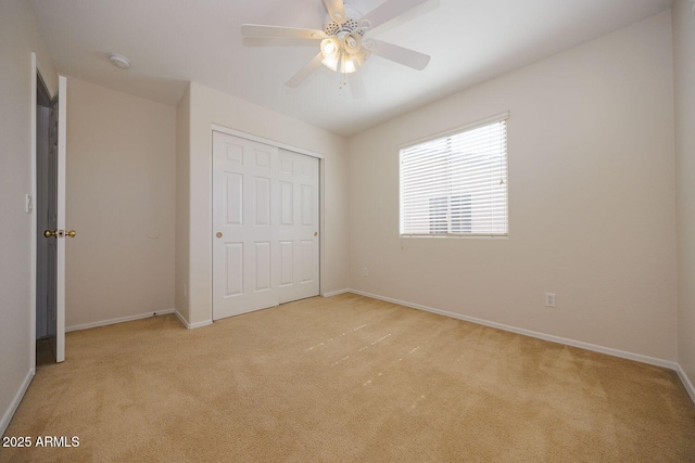 unfurnished bedroom featuring carpet floors, a ceiling fan, baseboards, and a closet