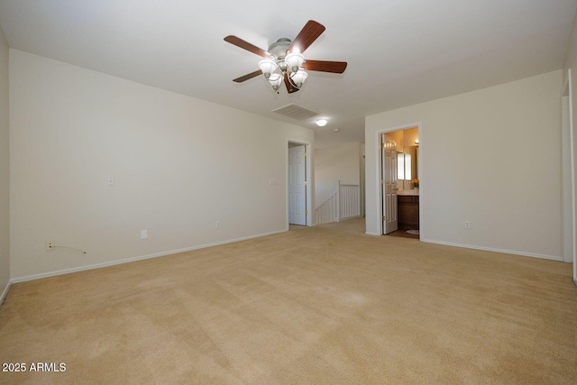 spare room with a ceiling fan, baseboards, visible vents, and light carpet