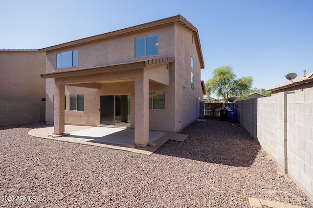 rear view of house featuring a patio, a fenced backyard, and stucco siding