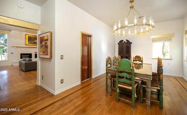 dining space featuring lofted ceiling, wood-type flooring, and a notable chandelier