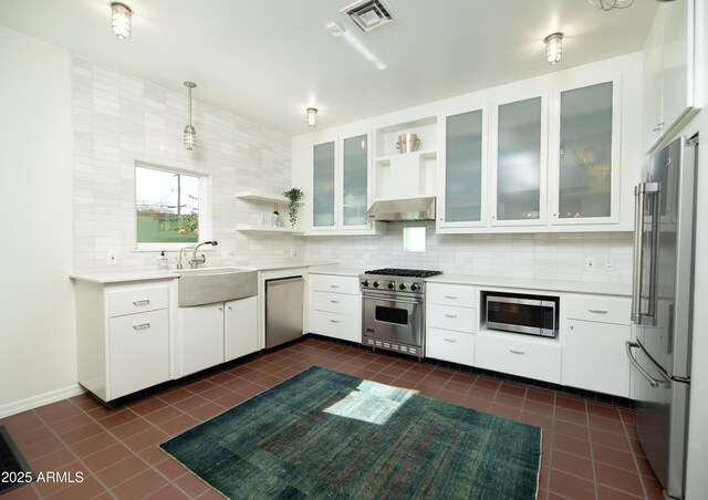 kitchen featuring pendant lighting, white cabinets, sink, and premium appliances