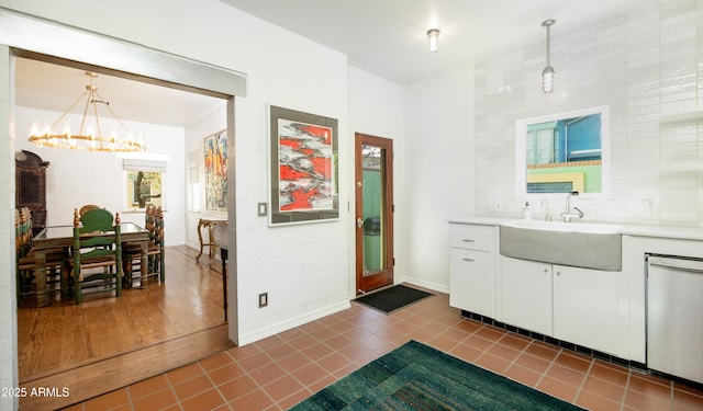 bathroom with vanity, tile patterned floors, backsplash, and an inviting chandelier