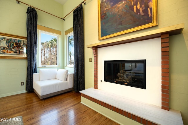 unfurnished room featuring wood-type flooring and brick wall