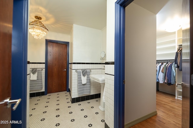 bathroom featuring tile walls and a notable chandelier