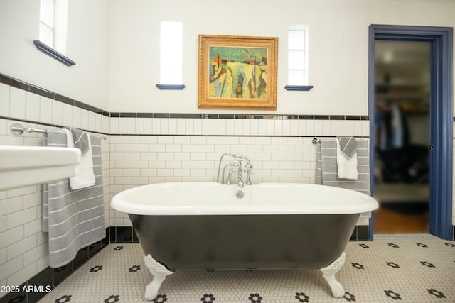 bathroom featuring plenty of natural light, tile patterned flooring, tile walls, and a washtub