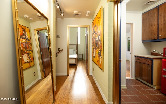 hall featuring sink, dark wood-type flooring, and rail lighting