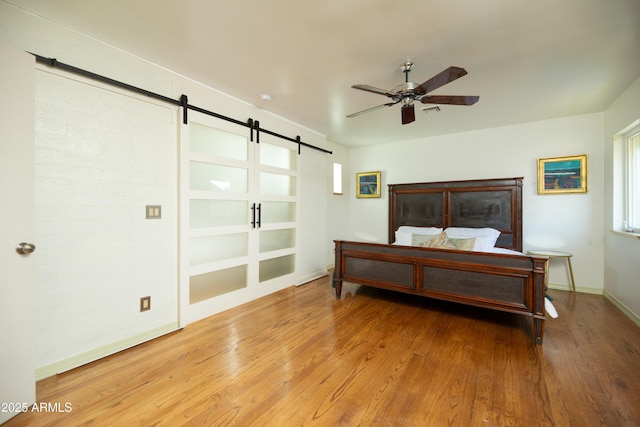 bedroom featuring wood-type flooring and a barn door