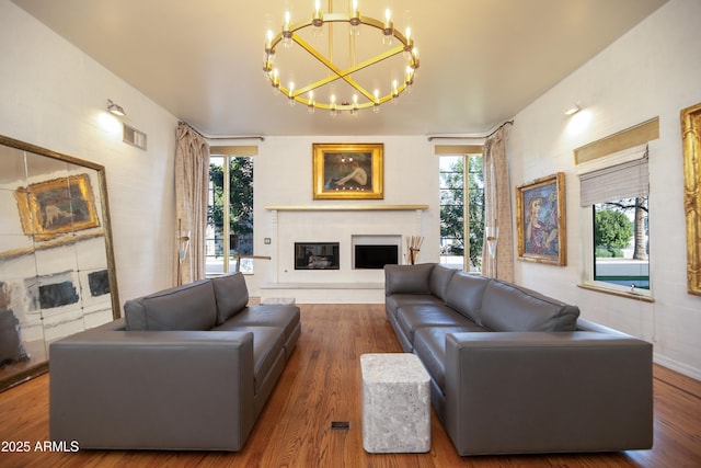 living room featuring a notable chandelier, wood-type flooring, and a healthy amount of sunlight