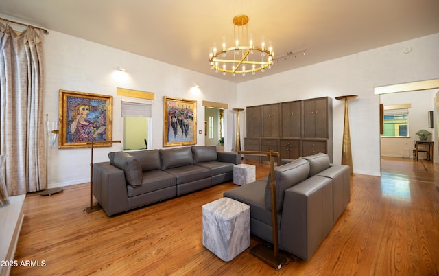 living room with a chandelier and light wood-type flooring