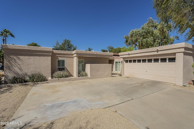 view of front of home featuring concrete driveway, a garage, and stucco siding