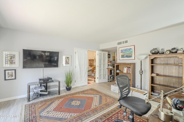 office with light wood finished floors, visible vents, and baseboards