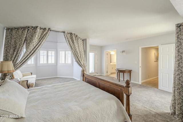 bedroom with connected bathroom, baseboards, and carpet flooring