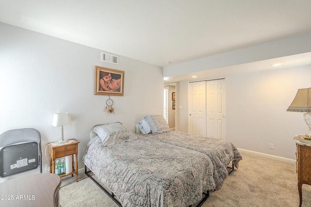 bedroom featuring a closet, visible vents, carpet flooring, and baseboards