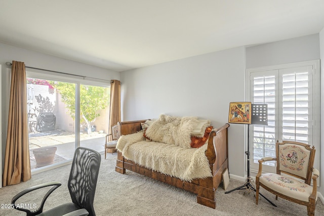 carpeted bedroom with baseboards and access to exterior