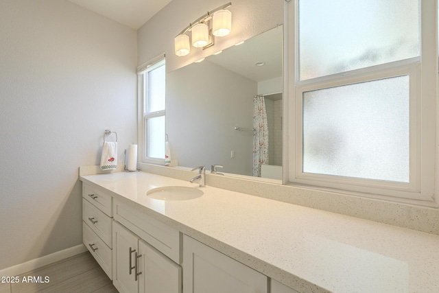 bathroom with a shower with curtain, vanity, and baseboards