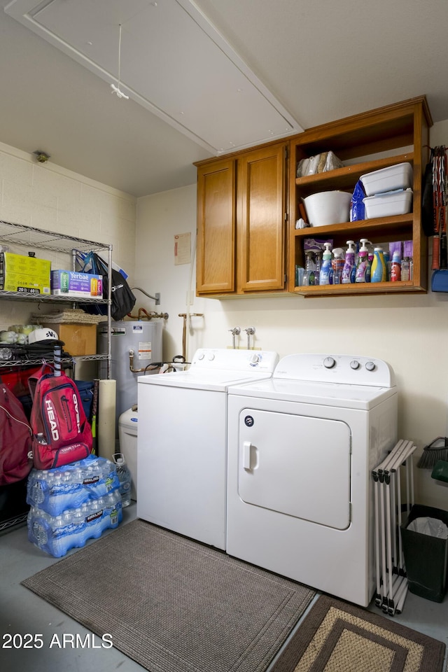 washroom with water heater, cabinets, and washer and dryer